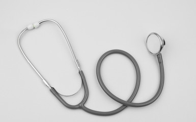 A single normal stethoscope isolated on top of a white color paper background