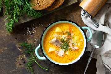 Norwegian cuisine. Soup with cream and salmon on a rustic wooden table. Top view flat lay...
