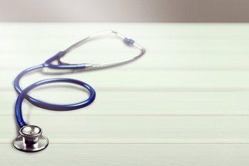 Classic medical stethoscope on the wooden desk