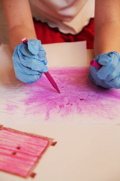 
The girl in the corontine wore disposable gloves and draws with a flamaster on paper.