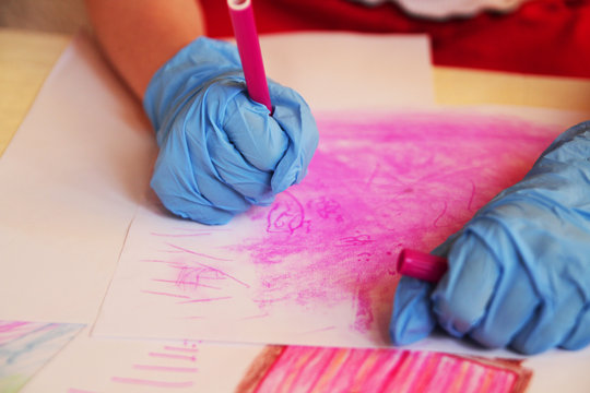 
The girl in the corontine wore disposable gloves and draws with a flamaster on paper.