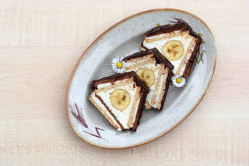 Slices of unbaked dessert in triangle shape made of flat light and dark biscuits