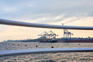 Fototapeta premium Cargo container terminal of sea freight industrial port. Lifting cargo cranes