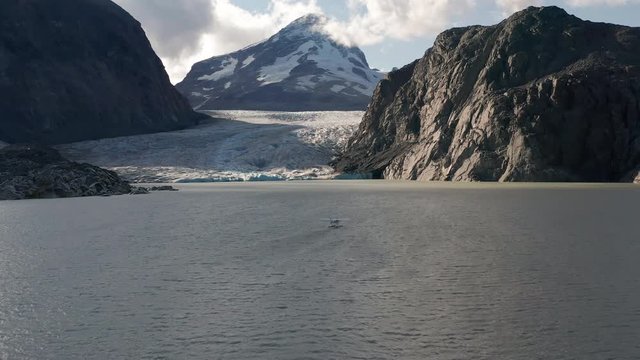A drone shot of a Sea plane on a glacier lake in the mountains of British Columbia before take off
