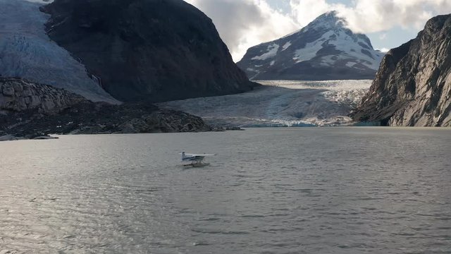 A drone shot of a Sea plane on a glacier lake in the mountains of British Columbia before take off