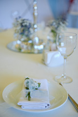 Table set with blank guest card, plate with white napkin and cutlery on table, copy space. Place setting at wedding reception. Table served for wedding banquet in restaurant