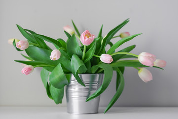 Beautiful spring white tulips in an abstract vase on the shelf, interior, sunny room