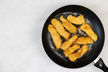 Flat lay above Frying chicken meat with breadcrumbs in the frying pan