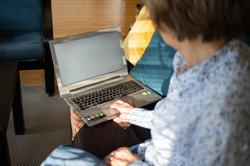 Fototapeta na wymiar connecting online during coronavirus pandemic elderly woman with laptop chatting in their living room