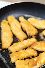 Frying chicken meat with breadcrumbs in the frying pan