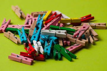 Multicolored decorative wooden clothespins on a green background