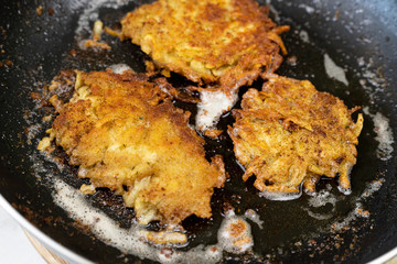 Frying grated potatoes pancakes in the frying pan