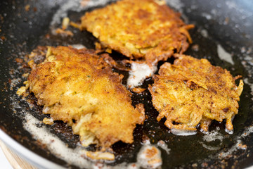 Frying grated potatoes pancakes in the frying pan