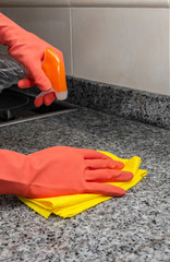 Unrecognizable woman's hands with protective gloves cleaning the house