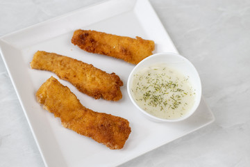 Fried chicken meat with breadcrumbs served with dill sauce