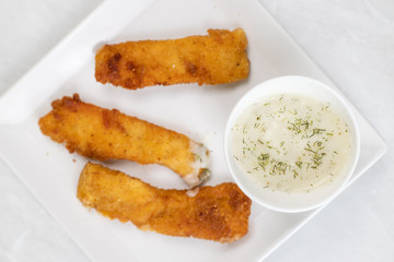 Fried chicken meat with breadcrumbs served with dill sauce