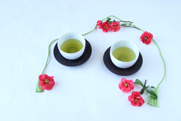 Fototapeta na wymiar 赤いボケの花と日本茶と緑のタッセル（フレーム）