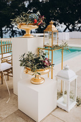 Wedding decorations. The ceremony area in the villa by the pool overlooking the sea is decorated with flower arrangements, golden vases and candles