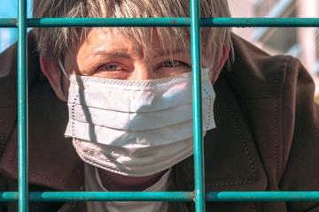 Masked woman behind bars
Coronavirus protection. Stop: Stay home. Do not infect, Covid-19.