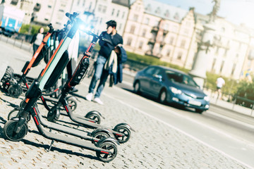 Background of sharing electric scooter parked on sidewalk summer sunlight using phone mobile app for rent. use in smart urban city in europe help transportation, traffic, safe environment pollution