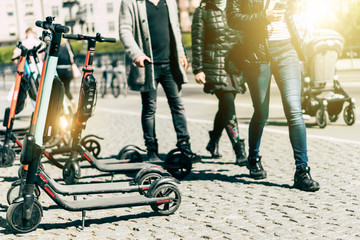 Fototapeta premium Background of sharing electric scooter parked on sidewalk summer sunlight using phone mobile app for rent. use in smart urban city in europe help transportation, traffic, safe environment pollution