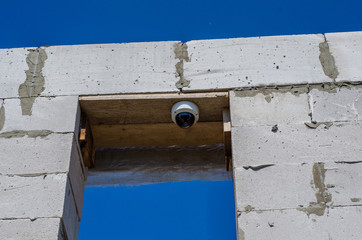 security camera on an unfinished brick building