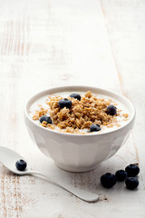 Muesli in a bowl on white wooden background