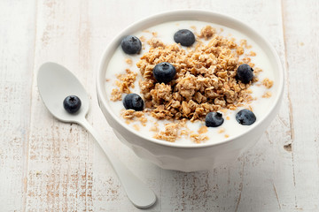 Muesli in a bowl on white wooden background