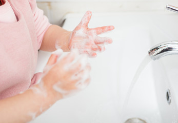 Children wash their hands with disinfectant foam to maintain health and kill viruses.