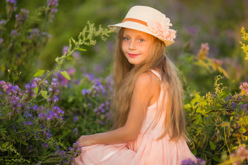 Summer holidays, nature, childhood, beauty. Portrait of child girl in hat in meadow, golden hour