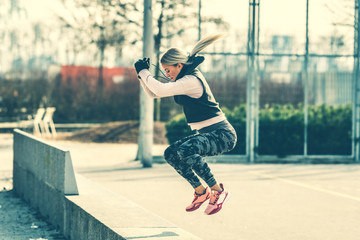 Fototapeta na wymiar Young Caucasian woman doing squat jump