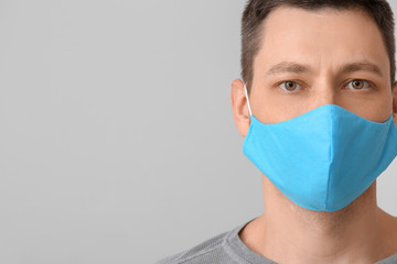 Man in protective medical mask on grey background