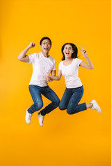 Fototapeta na wymiar Image of multinational couple making winner gesture while jumping