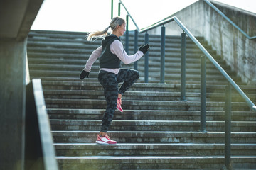 Young Caucasian woman doing exercises on a staircase