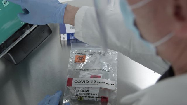 Over The Shoulder Look Of Medical Personnel Working On Covid-19 Kit Using Touch Screen Computer In Lab.