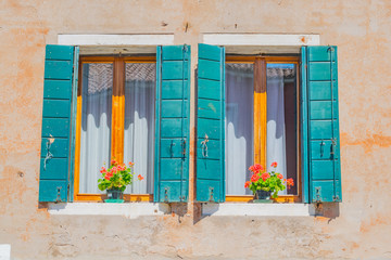 blue window with shutters and flowers