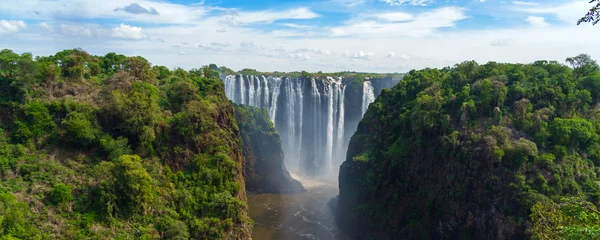 Fototapete Panorama view with dramatic waterfall and clouds at Victoria Falls, Zambezi River, Zimbabwe, Zambia. © ggfoto