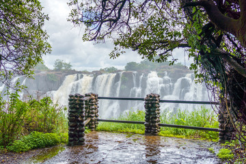 View to dramatic clouds and waterfall at Victoria Falls on the Zambezi River, Zimbabwe, Zambia