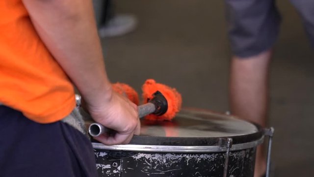 Slow motion shot of a drummer as he waits to preform in his drumming troupe.