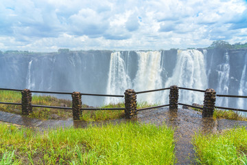View to the dramatic waterfall with clouds at Victoria Falls on the Zambezi River, Zimbabwe, Zambia.