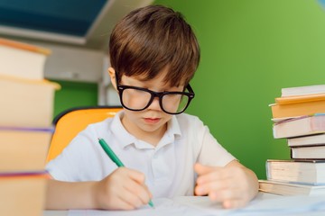 Child doing homework at home. Kids study and learn. Preschooler kid writing and reading. Back to school.