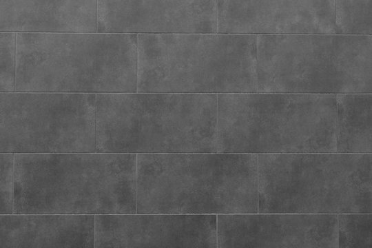 The texture of the black tile wall. Background of black tiled wall. Rectangular tile.