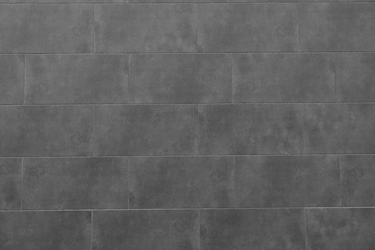 The texture of the black tile wall. Background of black tiled wall. Rectangular tile.