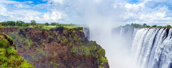 Foto op Aluminium Panorama view with dramatic clouds and waterfall at Victoria Falls on the Zambezi River, Zimbabwe, Zambia. Copy space for text © ggfoto