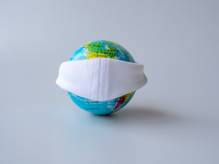 Earth wearing white fabric mask to flight corona virus, world with protective mask to prevent covid-19, dust, pm 2.5. Save life and world concept.