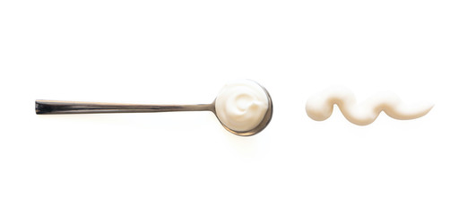 Spoon with mayonnaise and sauce splash isolated on white background, top view. Close-up seasoning...
