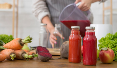Unrecognizable woman pouring a red cocktail into a bottle