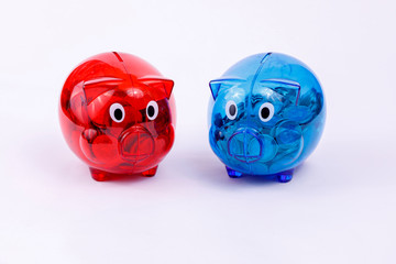 Rotes und Blaues Sparschwein gef&uuml;llt mit M&uuml;nzgeld