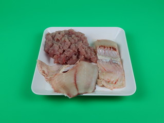 Fresh fish slices ready to cook isolated on green background.