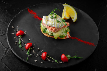 Bruschetta with salmon, avocado, poached egg, guacamole. Perfect chic diet breakfast.